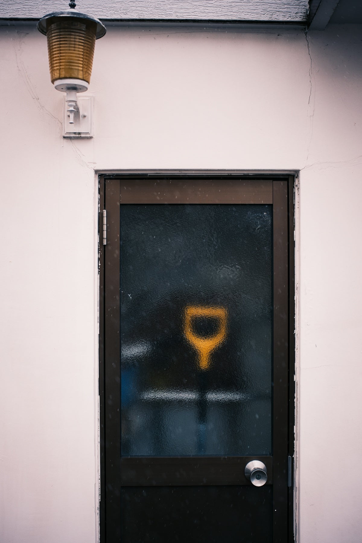 A frosted glass door with a yellow shovel symbol.