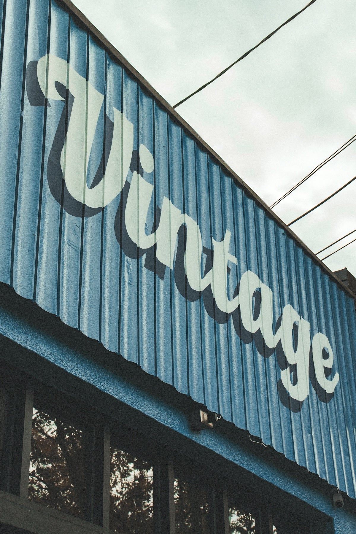A blue corrugated metal sign with the word Vintage in large white letters