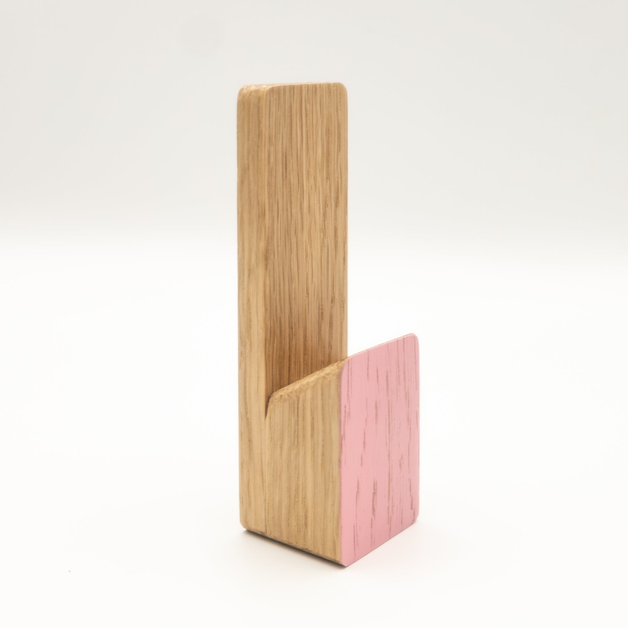 Wooden and pink phone stand on a white background