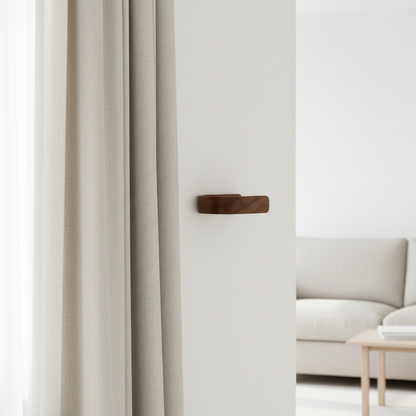 Light gray curtain with a walnut curtain holdback in a minimalistic room.