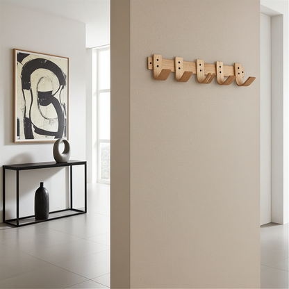 Modern interior with abstract art, black console table, and wooden wall hooks.