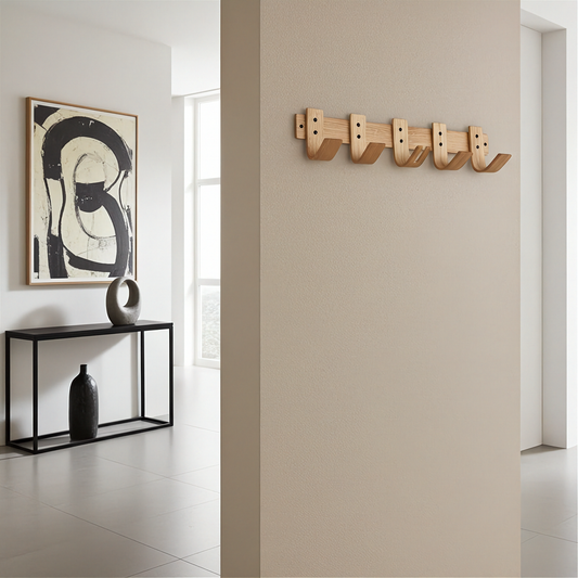 Modern interior with abstract art, black console table, and wooden wall hooks.